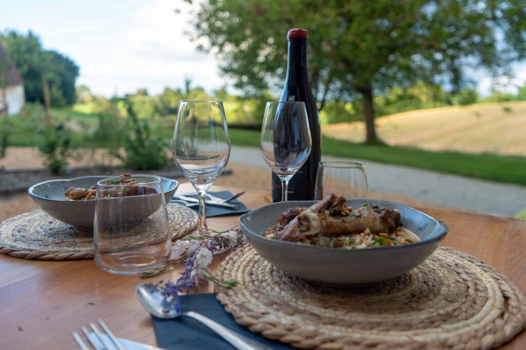 Salle du restaurant et terrasse du Domaine des Écuries dans le Perche. Une table en pleine nature